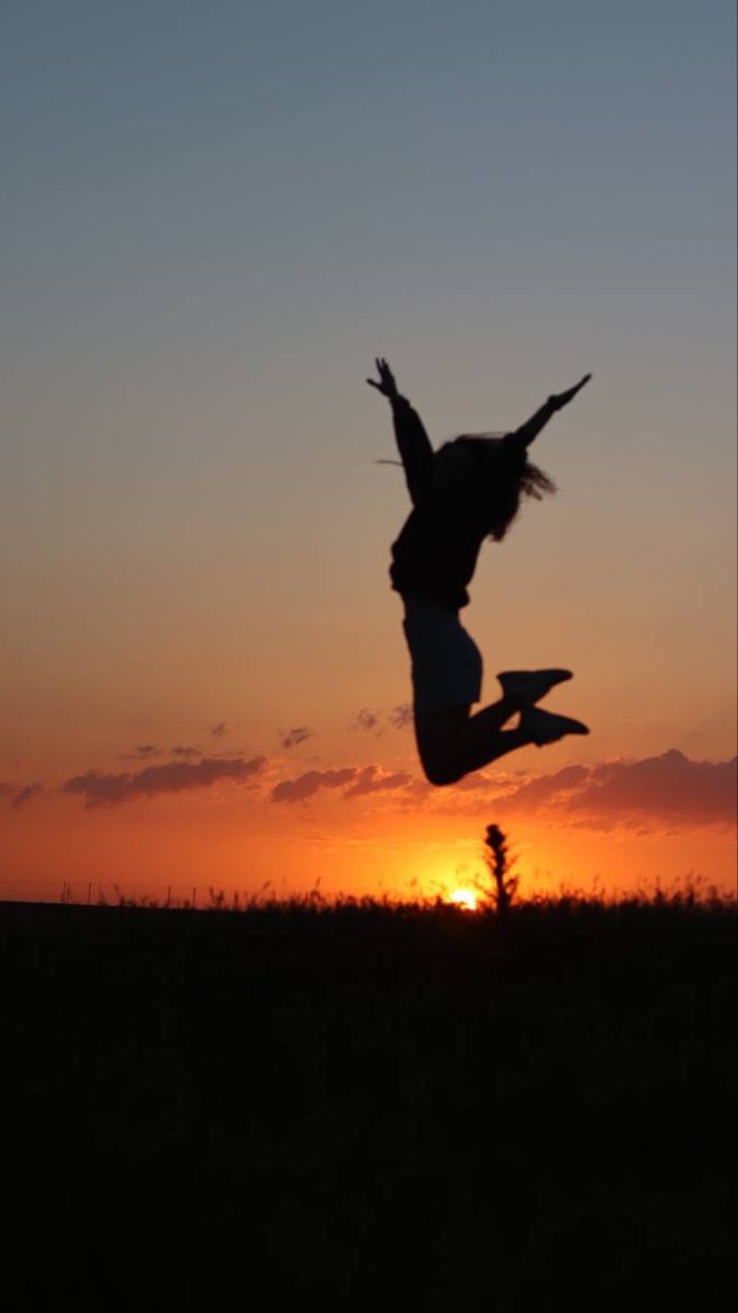 This may contain: a person jumping in the air at sunset
