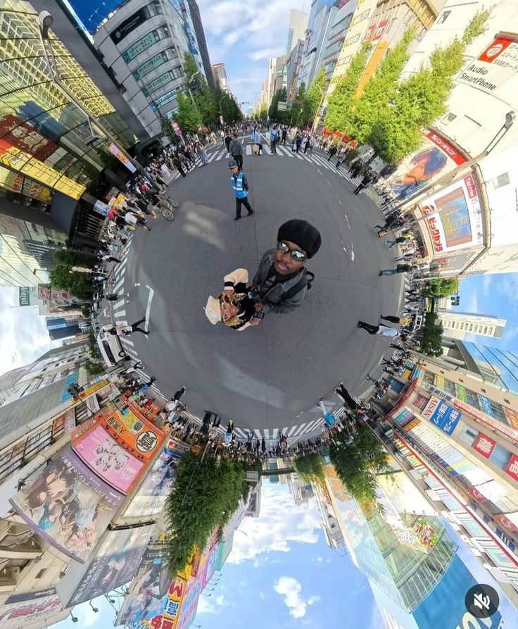This may contain: an aerial view of people standing in the middle of a street with buildings on both sides