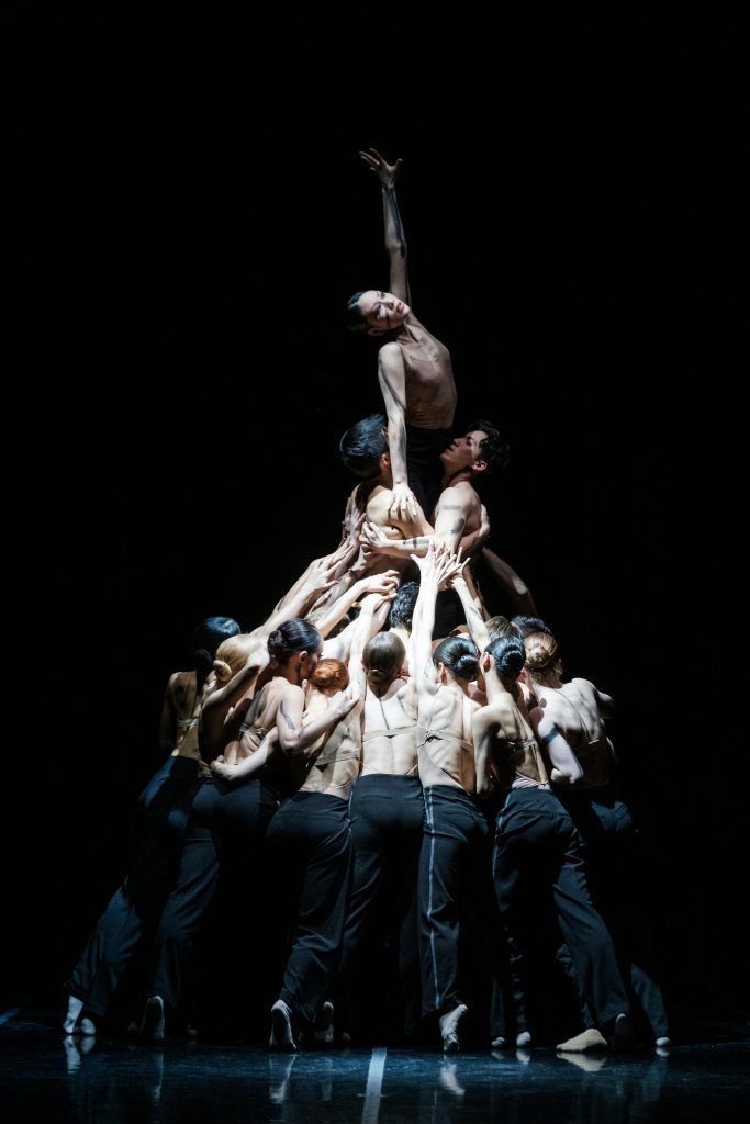 This may contain: a group of people standing on top of each other