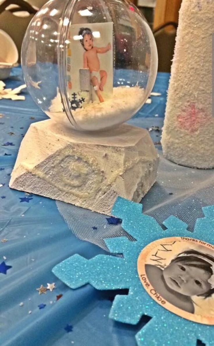 This may contain: a snow globe sitting on top of a blue tablecloth covered table with stars and other decorations
